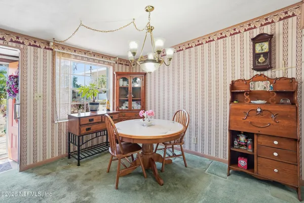 a view of a livingroom with furniture wooden floor front door and a chandelier