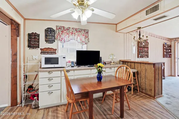 a kitchen with stainless steel appliances granite countertop a refrigerator a stove and white cabinets with wooden floor