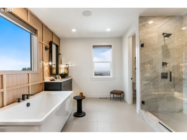 a spacious bathroom with a tub sink and mirror
