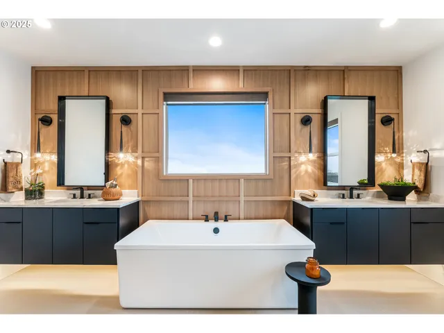 a bathroom with a tub a sink and a large mirror