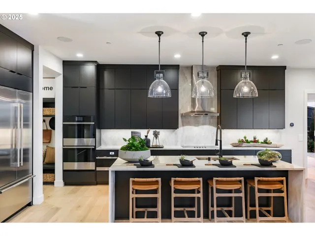 a kitchen with stainless steel appliances kitchen island granite countertop a table and chairs in it