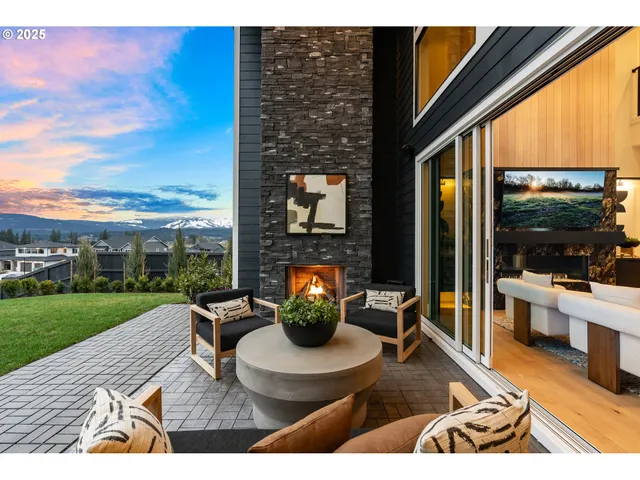 a living room with furniture a fireplace and floor to ceiling windows