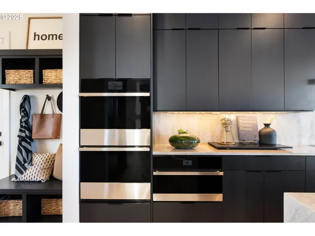 a kitchen with stainless steel appliances granite countertop a sink a stove and entryway