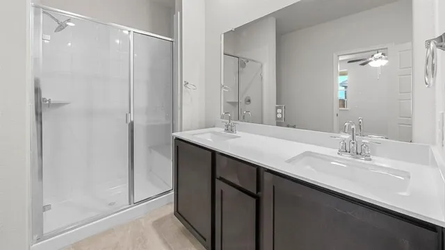 a bathroom with a double vanity sink mirror and shower