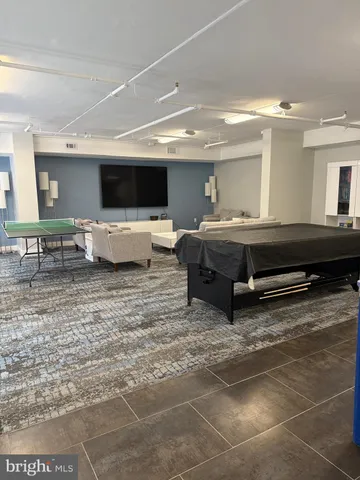 a living room with furniture a flat screen tv and kitchen view