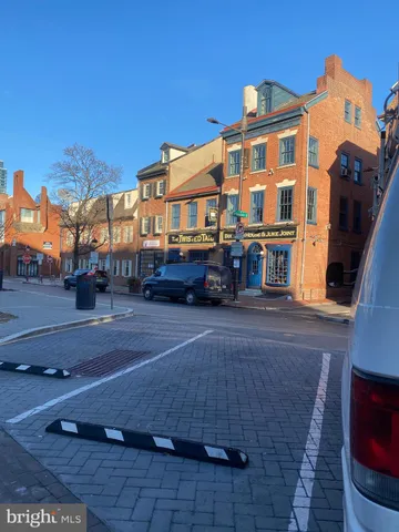 a front view of a building with streets and trees