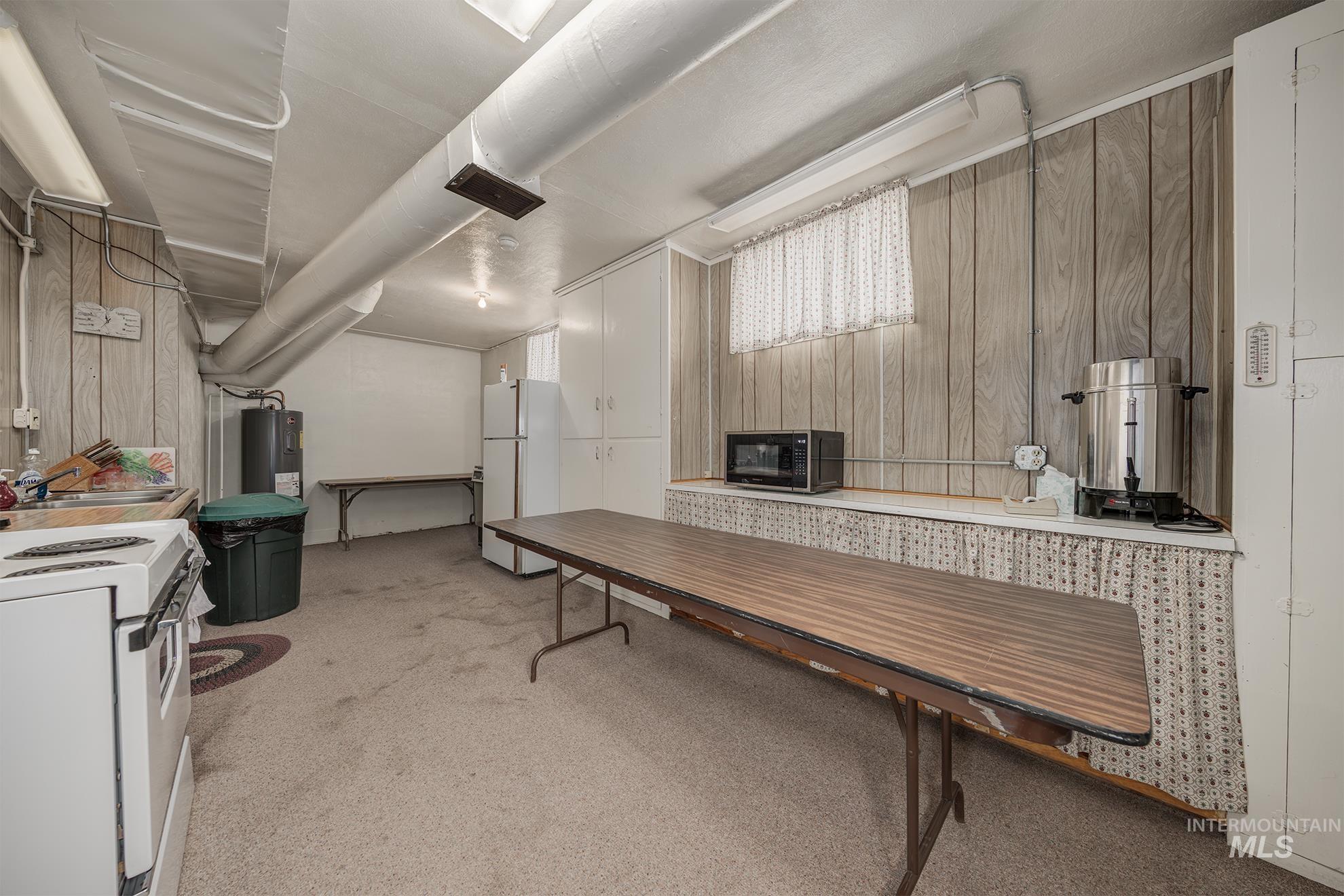 404 North 3rd Street Nyssa, OR 97913 - Photo 22 of 30 Basement with wood walls, light carpet, freestanding refrigerator, and electric water heater