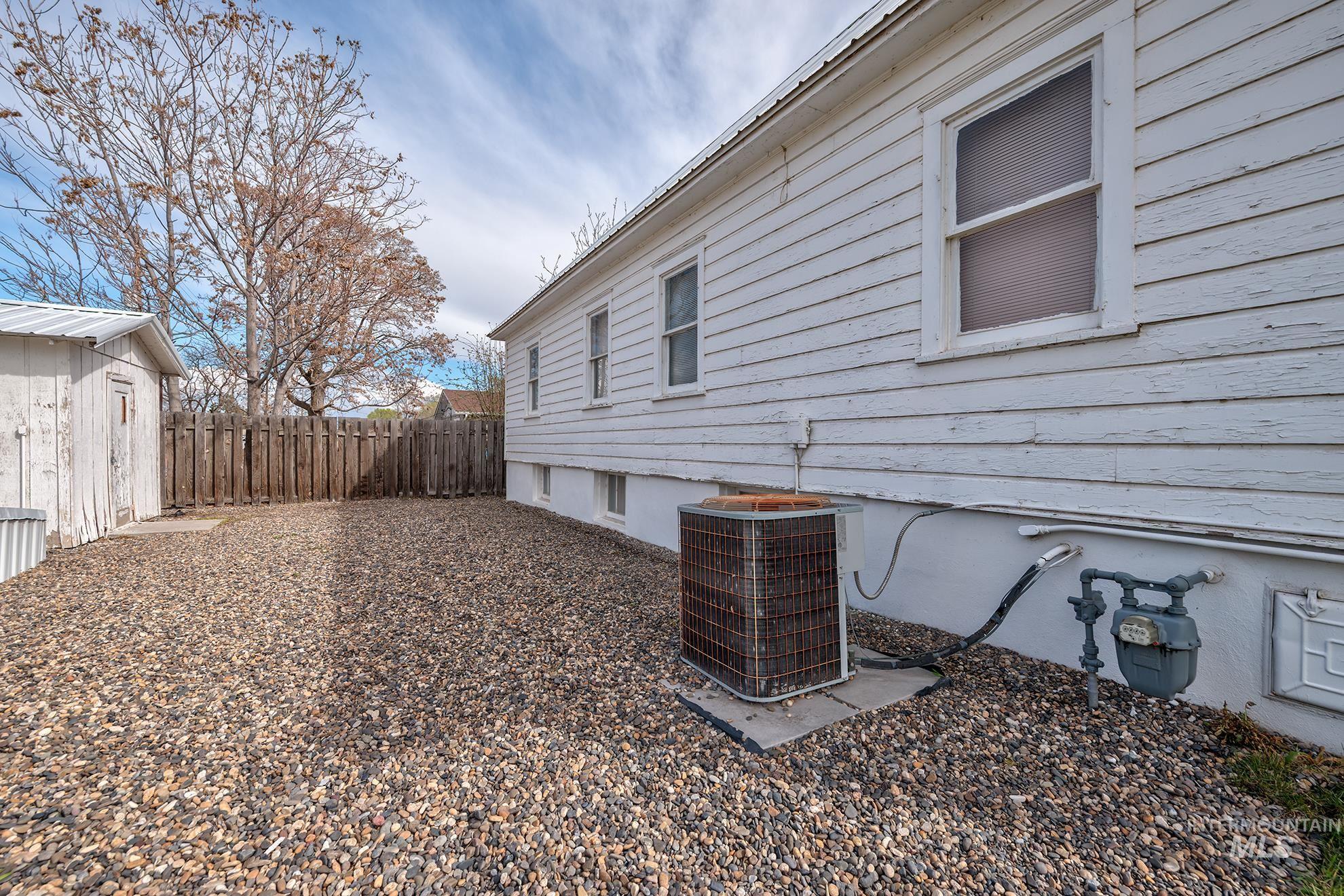 404 North 3rd Street Nyssa, OR 97913 - Photo 28 of 30 View of side of home featuring a fenced backyard and a cooling unit