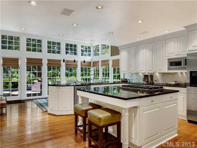 2726 Sharon Road Charlotte, NC 28211 - Photo 12 of 16 a large kitchen with stainless steel appliances granite countertop a stove and a dining table chair