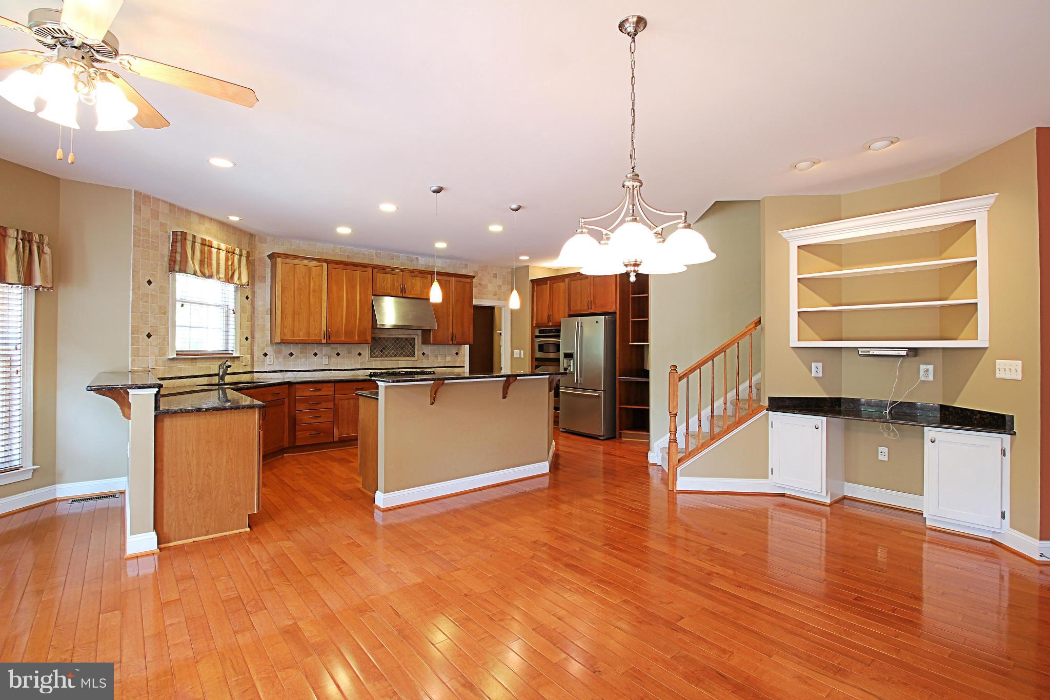 68 Willow Ridge Court Fredericksburg, VA 22406 - Photo 14 of 30 a open kitchen with stainless steel appliances granite countertop a refrigerator a sink dishwasher with a dining table and chairs with wooden floor