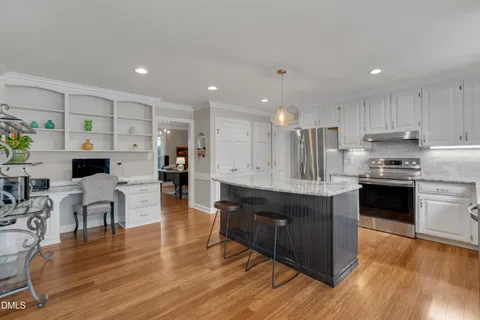 a kitchen with stainless steel appliances granite countertop wooden floors stove top oven and cabinets with wooden floor
