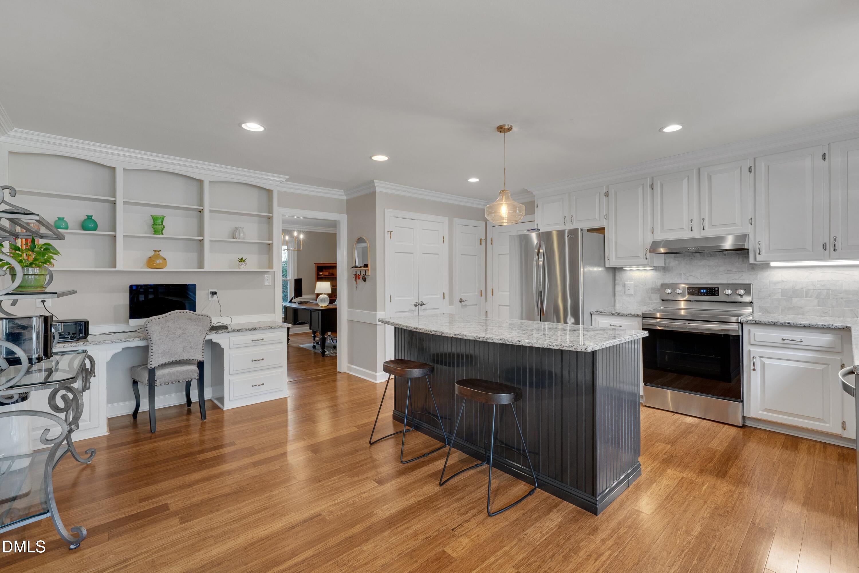 7900 Kingsland Drive Raleigh, NC 27613 - Photo 11 of 32 a kitchen with stainless steel appliances granite countertop wooden floors stove top oven and cabinets with wooden floor