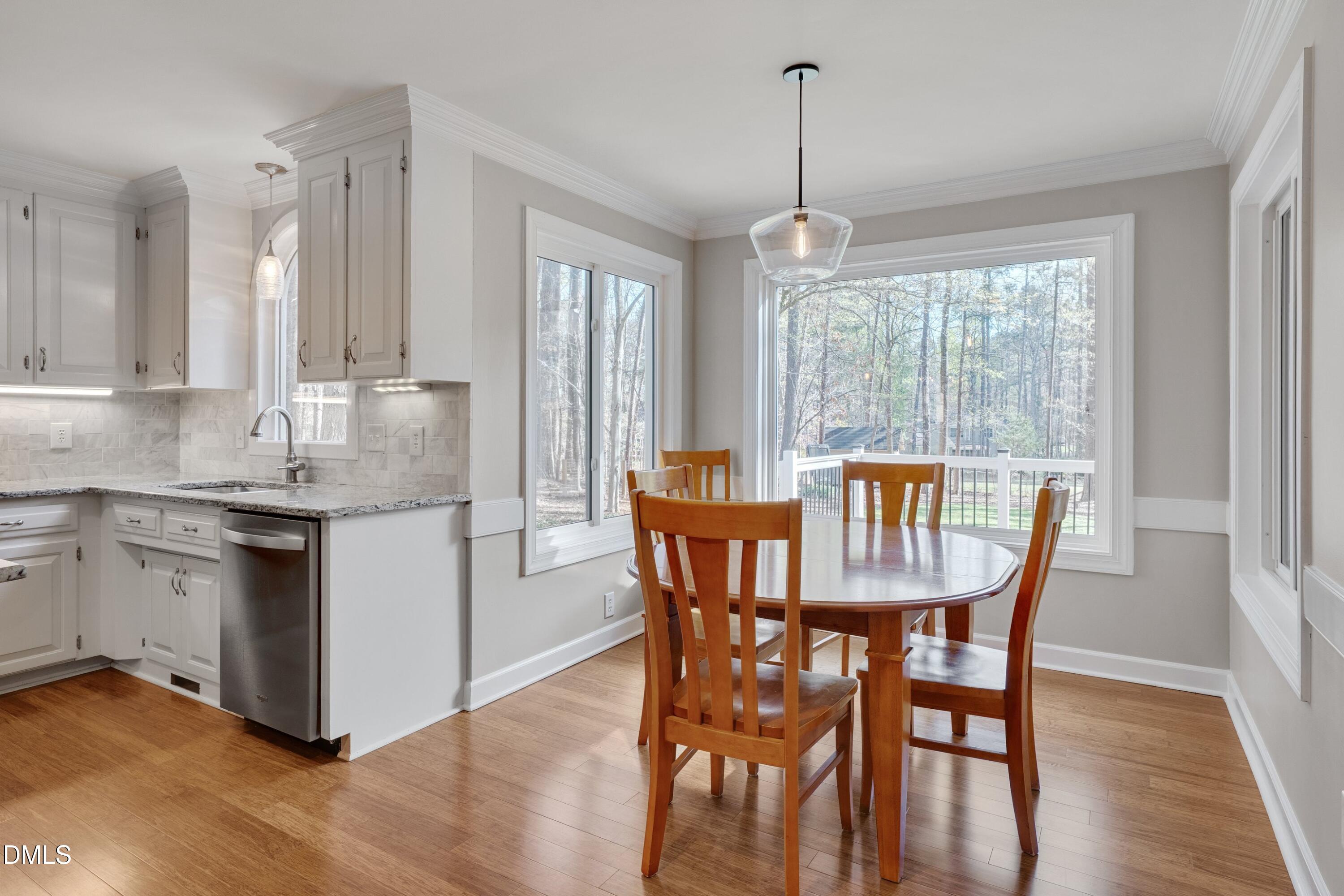 7900 Kingsland Drive Raleigh, NC 27613 - Photo 12 of 32 a kitchen with stainless steel appliances granite countertop a dining table chairs and granite counter tops