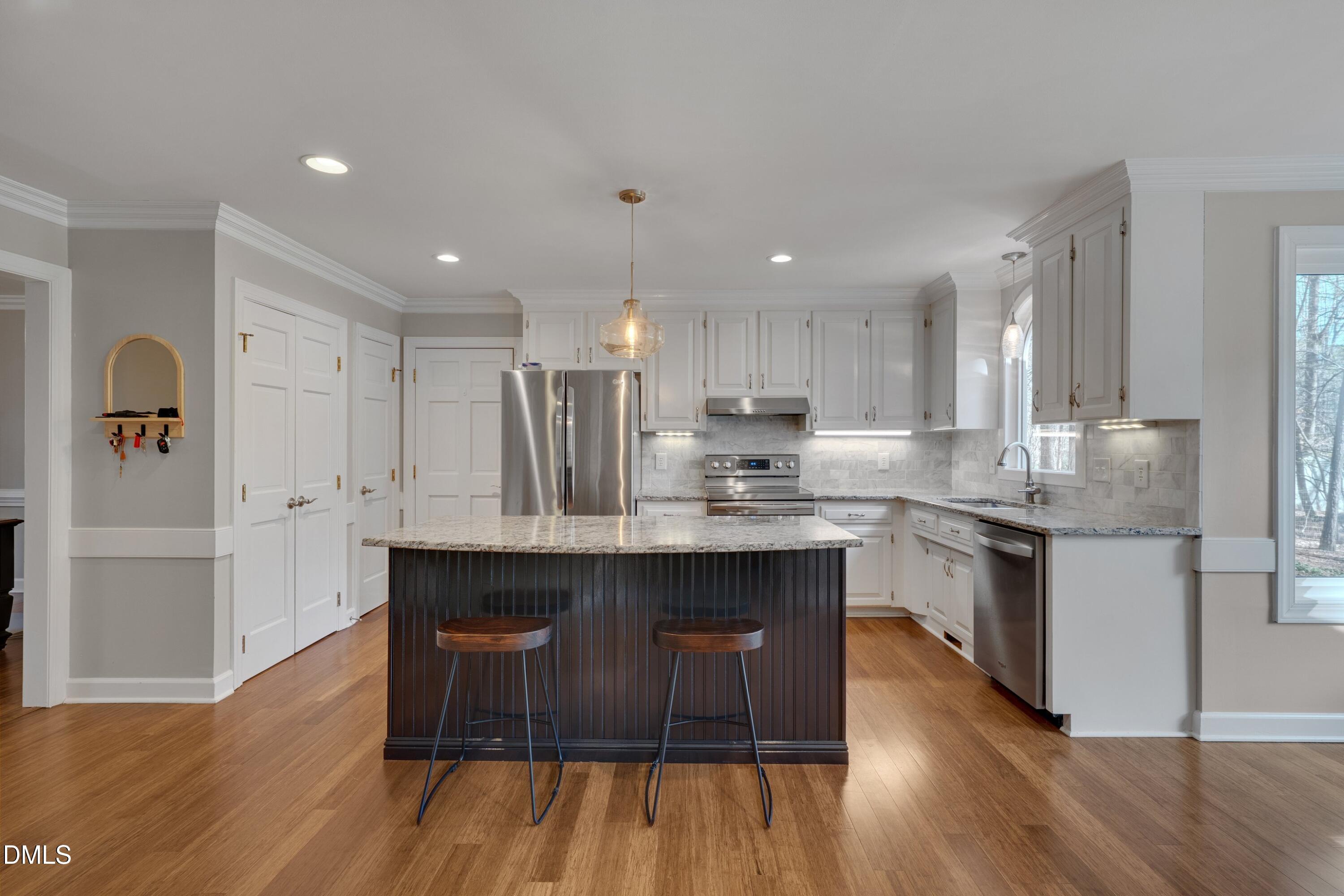7900 Kingsland Drive Raleigh, NC 27613 - Photo 13 of 32 a kitchen with stainless steel appliances granite countertop a kitchen island hardwood floor sink stove and granite counter top