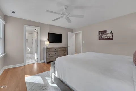 a spacious bedroom with a bed and a flat screen tv