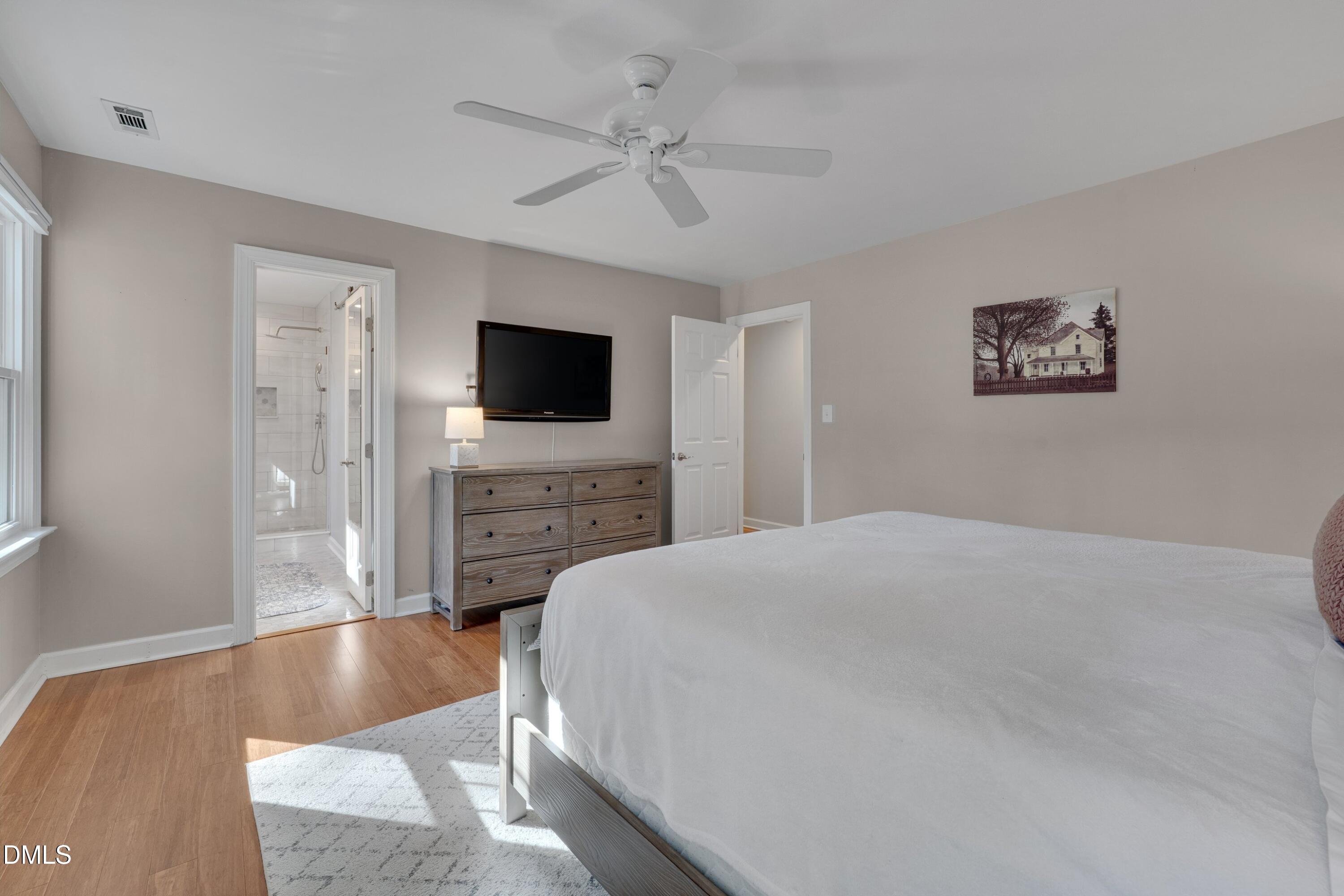 7900 Kingsland Drive Raleigh, NC 27613 - Photo 17 of 32 a spacious bedroom with a bed and a flat screen tv
