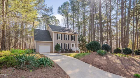 a front view of a house with a yard and trees