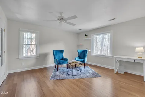 a work room with furniture wooden floor and windows