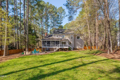 a view of a house with a big yard and large trees