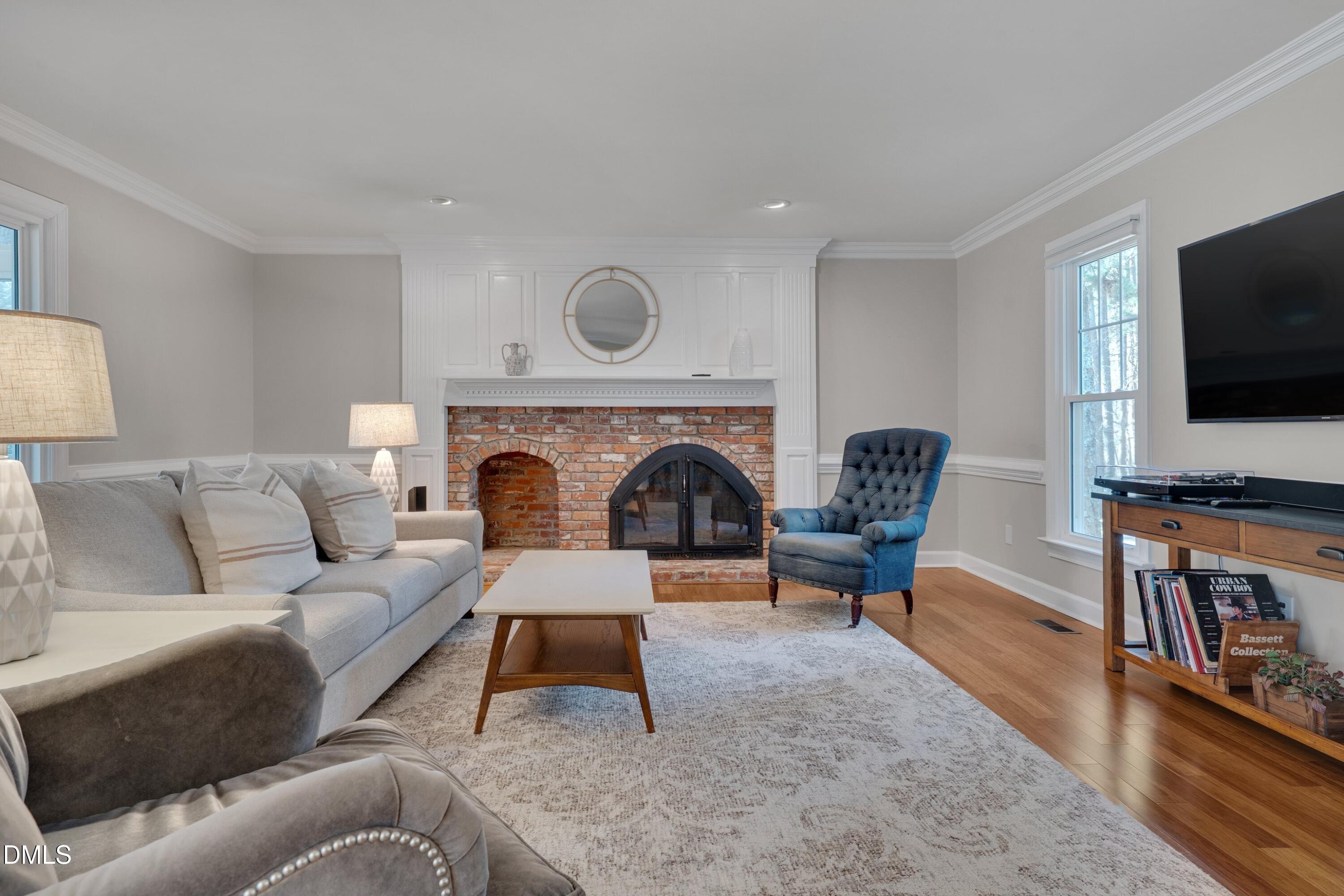 7900 Kingsland Drive Raleigh, NC 27613 - Photo 7 of 32 a living room with furniture a flat screen tv and a fireplace
