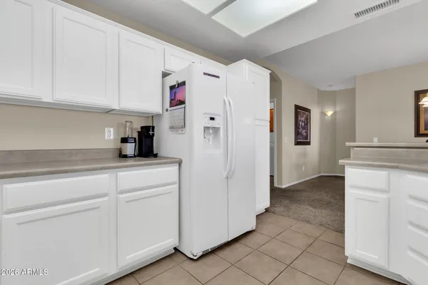 a kitchen with cabinets and a refrigerator