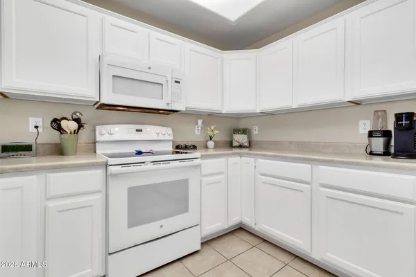 a kitchen with white cabinets and white appliances