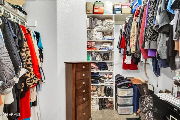 a view of walk in closet with clothes and shoes