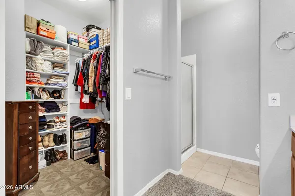 a view of walk in closet with clothes and shoes