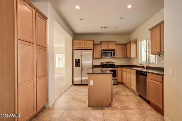 a kitchen with a refrigerator and a stove top oven