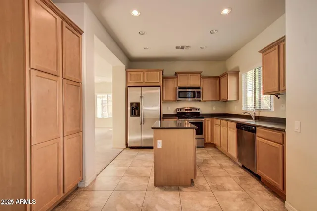 a kitchen with a refrigerator and a stove top oven
