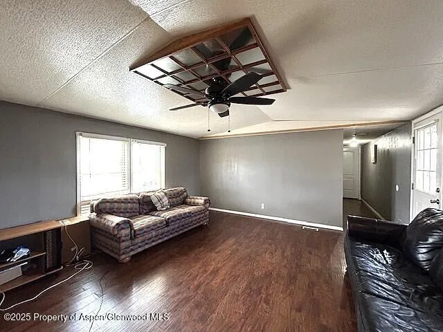 a living room with furniture a air conditioner and a wooden floor