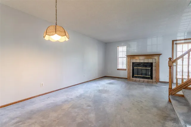 an empty room with a fireplace and window