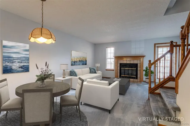 a living room with furniture a fireplace and a chandelier