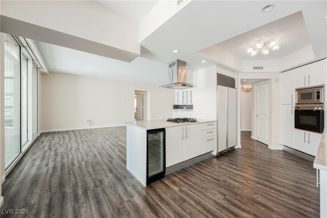 2877 Paradise Road, Unit 1604 Las Vegas, NV 89109 - Photo 13 of 47 Kitchen featuring dark wood-style floors, white cabinetry, built in appliances, island range hood, and recessed lighting