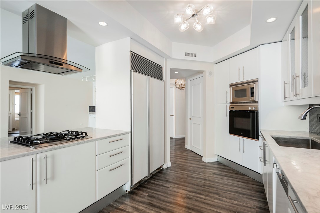 2877 Paradise Road, Unit 1604 Las Vegas, NV 89109 - Photo 15 of 47 Kitchen with ventilation hood, built in appliances, white cabinetry, dark wood-style flooring, and recessed lighting