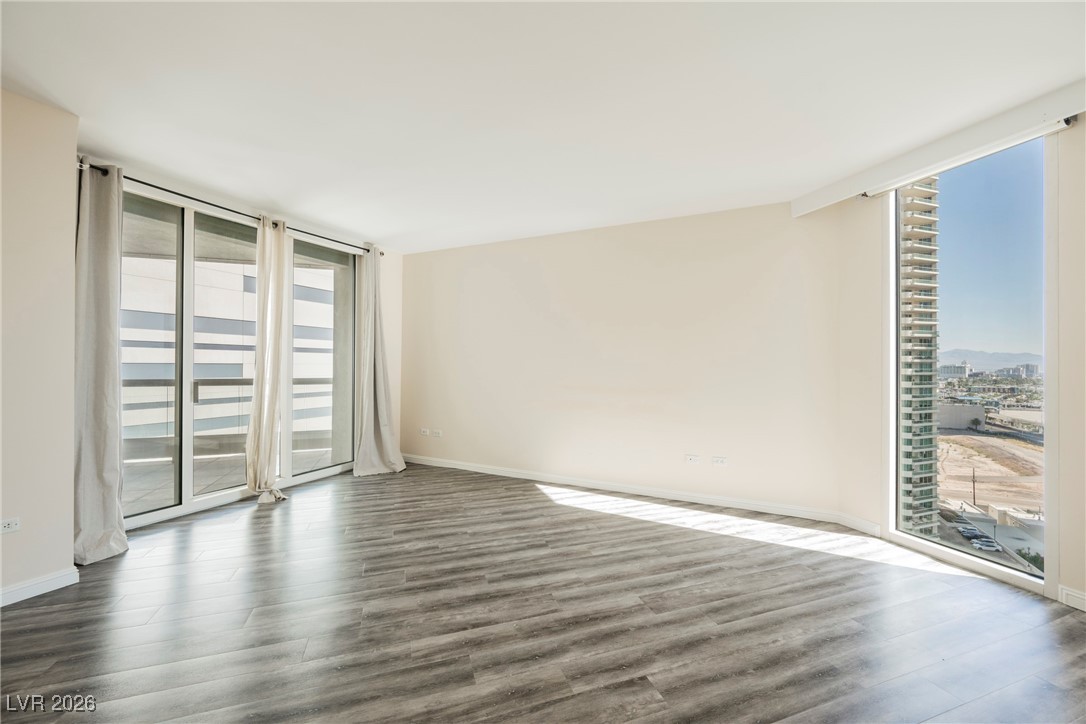 2877 Paradise Road, Unit 1604 Las Vegas, NV 89109 - Photo 19 of 47 Empty room with healthy amount of natural light, dark wood finished floors, and floor to ceiling windows