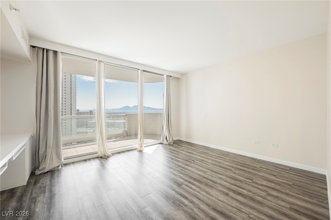 2877 Paradise Road, Unit 1604 Las Vegas, NV 89109 - Photo 21 of 47 Unfurnished room featuring dark wood-type flooring, floor to ceiling windows, and a mountain view
