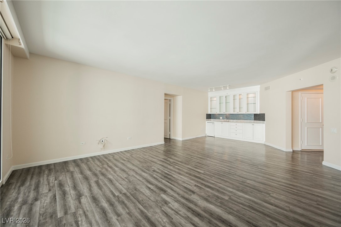 2877 Paradise Road, Unit 1604 Las Vegas, NV 89109 - Photo 9 of 47 Spare room featuring dark wood-type flooring and bar area