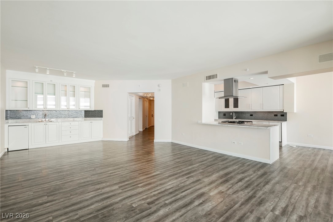 2877 Paradise Road, Unit 1604 Las Vegas, NV 89109 - Photo 10 of 47 Unfurnished living room featuring dark wood-style flooring and track lighting