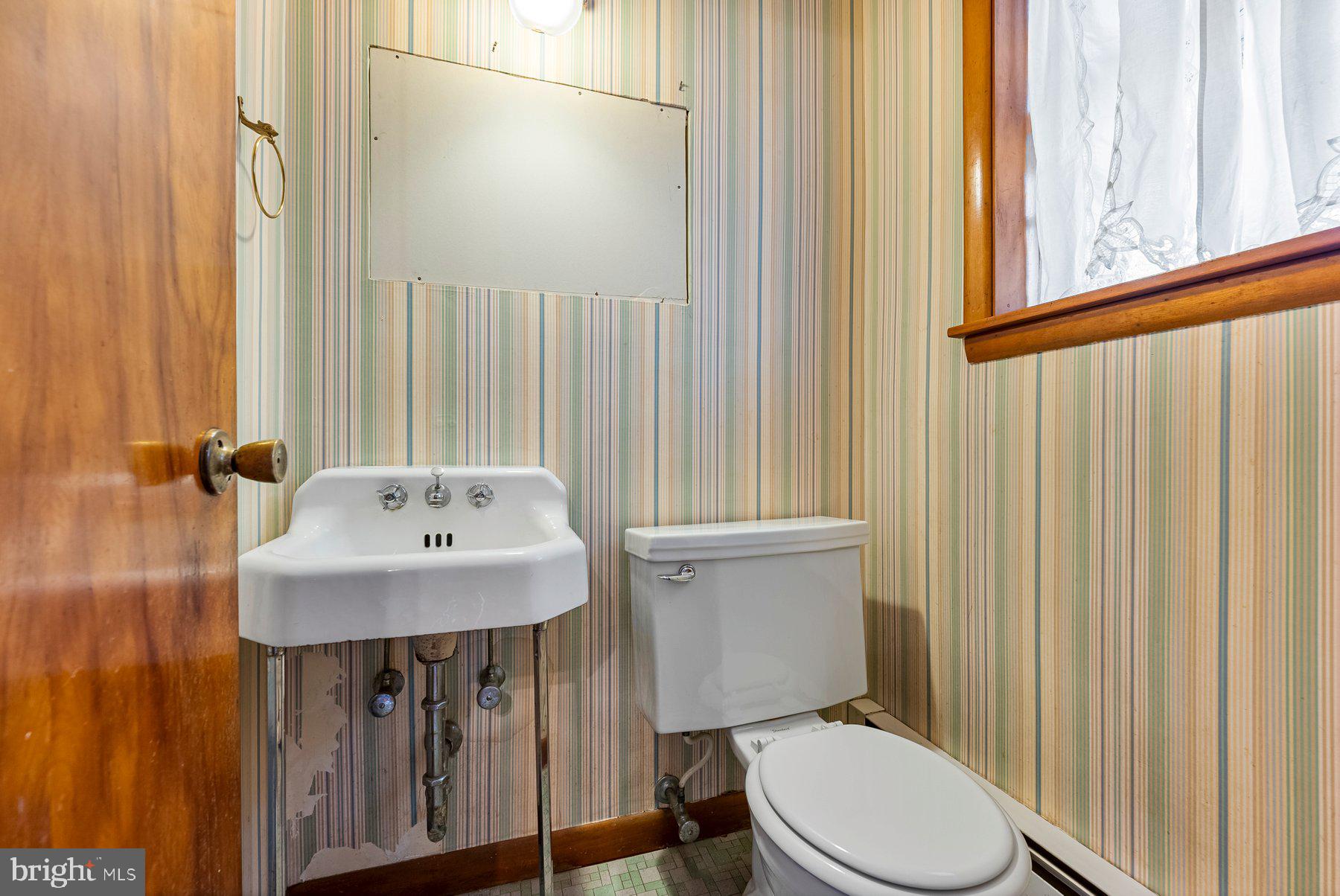 104 Hillside Road Baltimore, MD 21228 - Photo 20 of 34 a bathroom with a sink a toilet and mirror