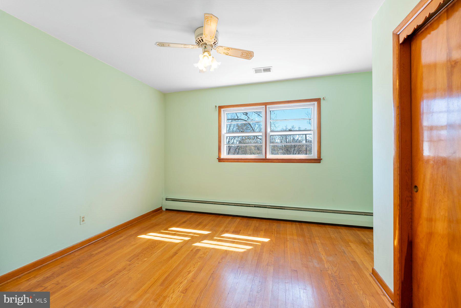 104 Hillside Road Baltimore, MD 21228 - Photo 23 of 34 an empty room with a window and wooden floor
