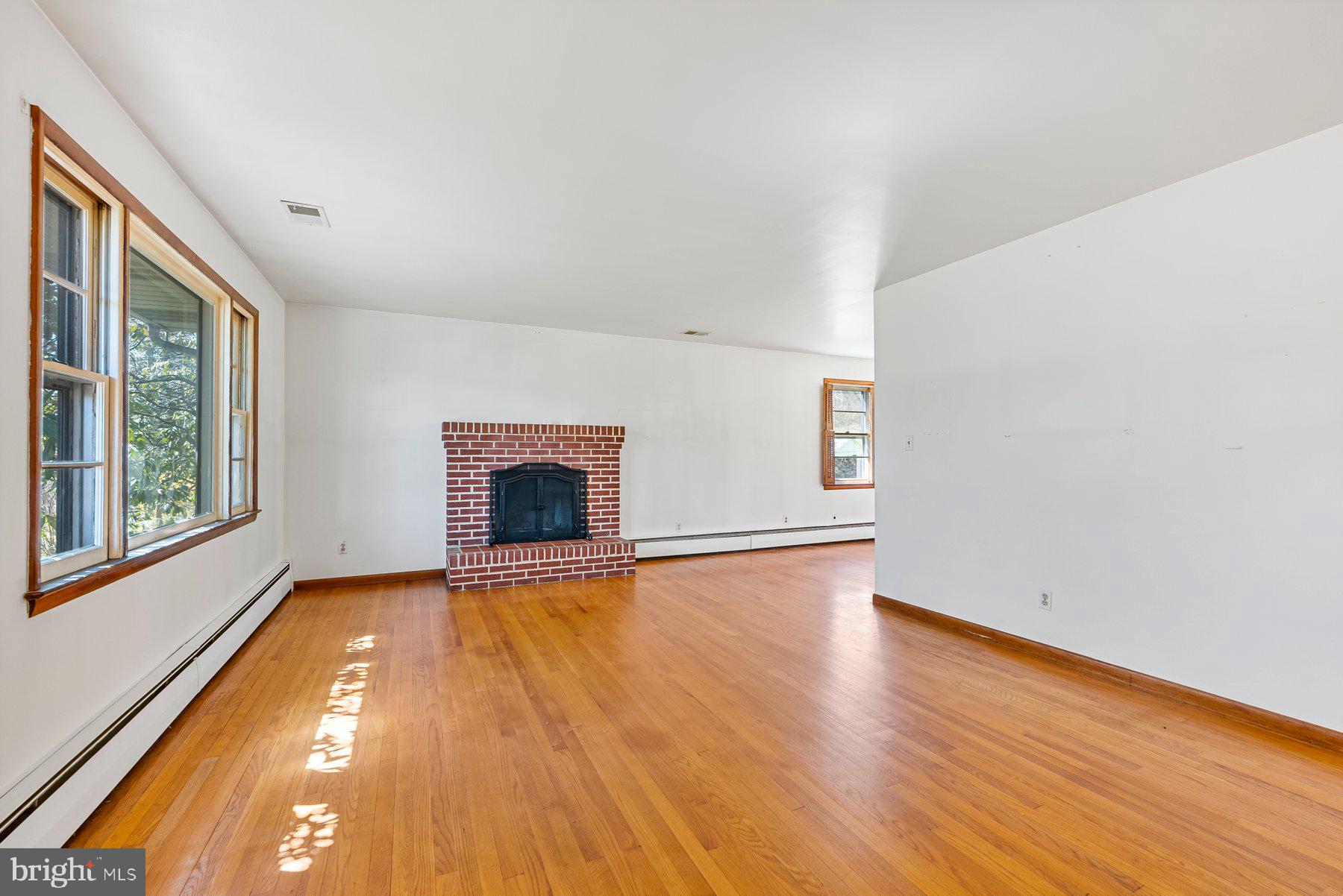104 Hillside Road Baltimore, MD 21228 - Photo 7 of 34 a view of an empty room with a fireplace and a window
