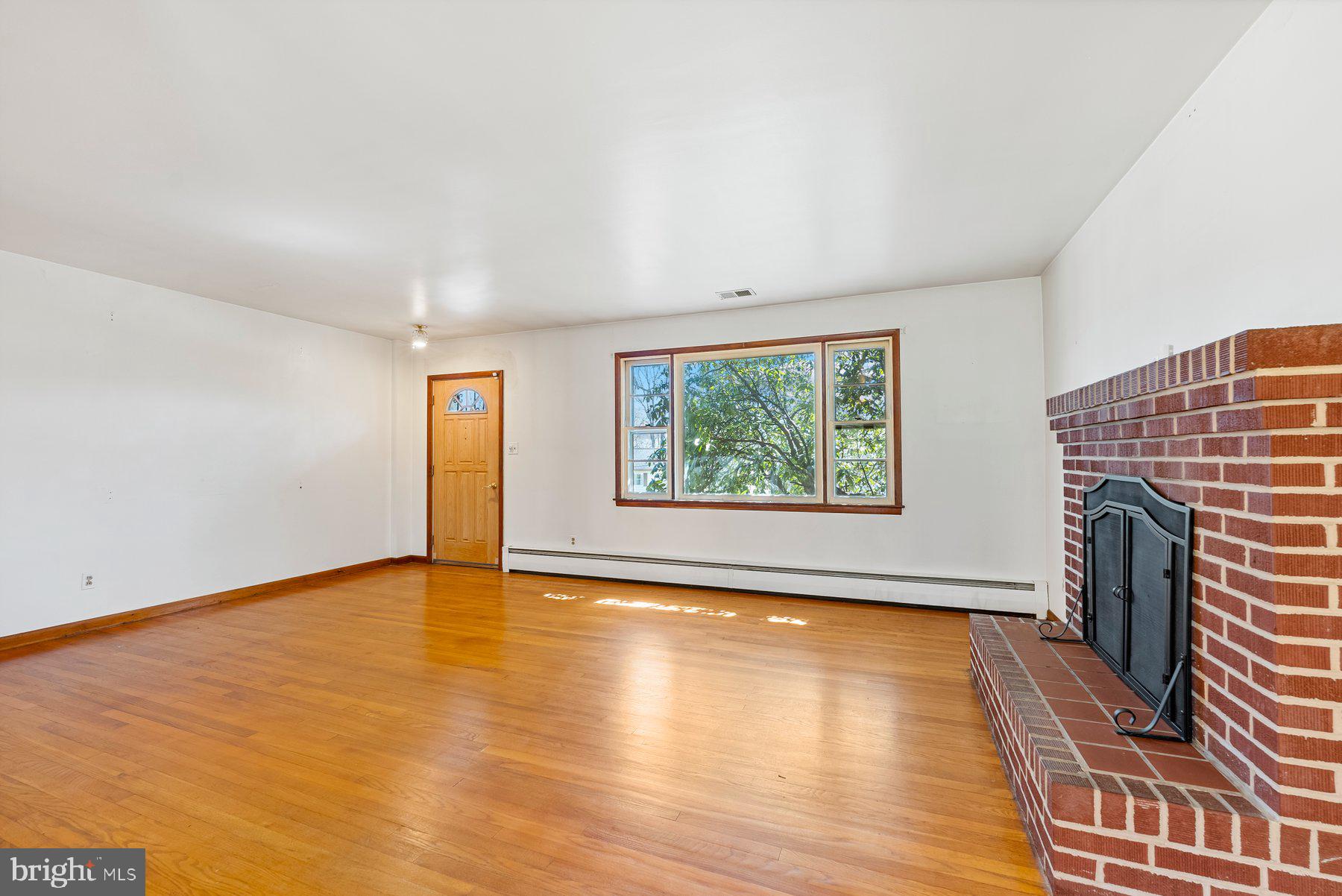 104 Hillside Road Baltimore, MD 21228 - Photo 8 of 34 an empty room with fireplace and wooden floor