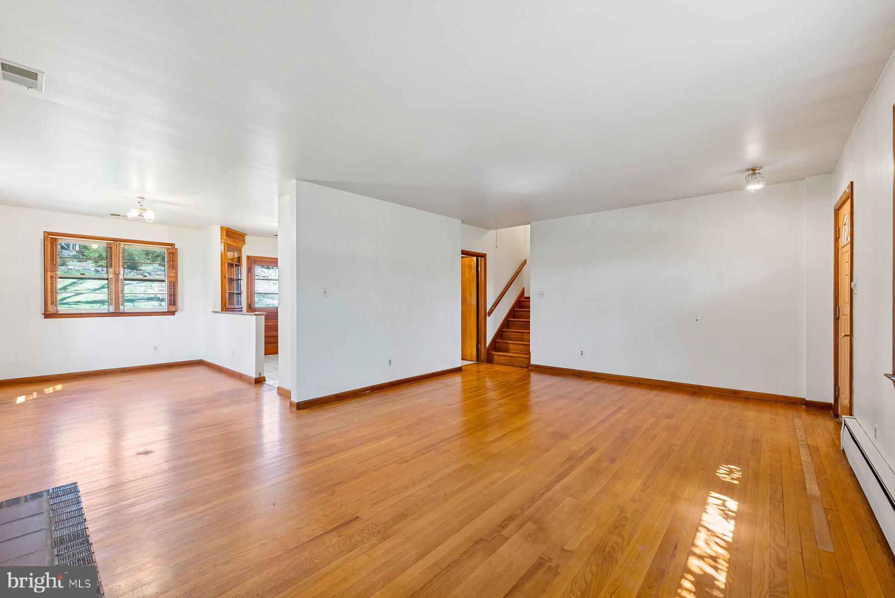 104 Hillside Road Baltimore, MD 21228 - Photo 9 of 34 a view of an empty room with wooden floor and a window
