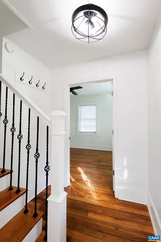 a view of a livingroom with wooden floor and stairs