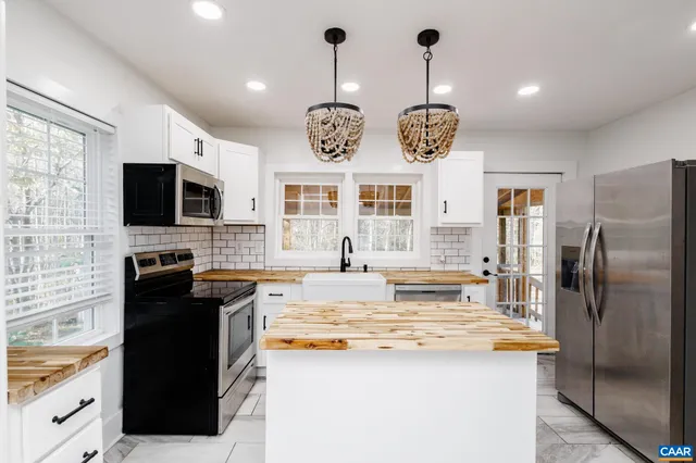 a kitchen with stainless steel appliances granite countertop a stove top oven a refrigerator a sink and dishwasher