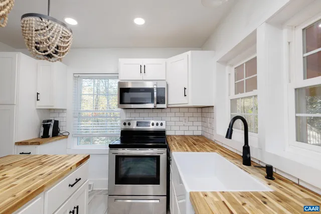 a kitchen with stainless steel appliances a stove a sink a microwave and cabinets