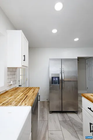 a kitchen with kitchen island a counter top space cabinets and stainless steel appliances