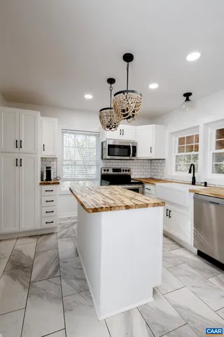 a large kitchen with stainless steel appliances a stove a sink dishwasher and a refrigerator