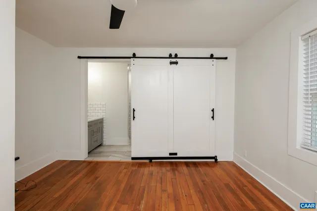 a view of room with hardwood floor and a ceiling fan